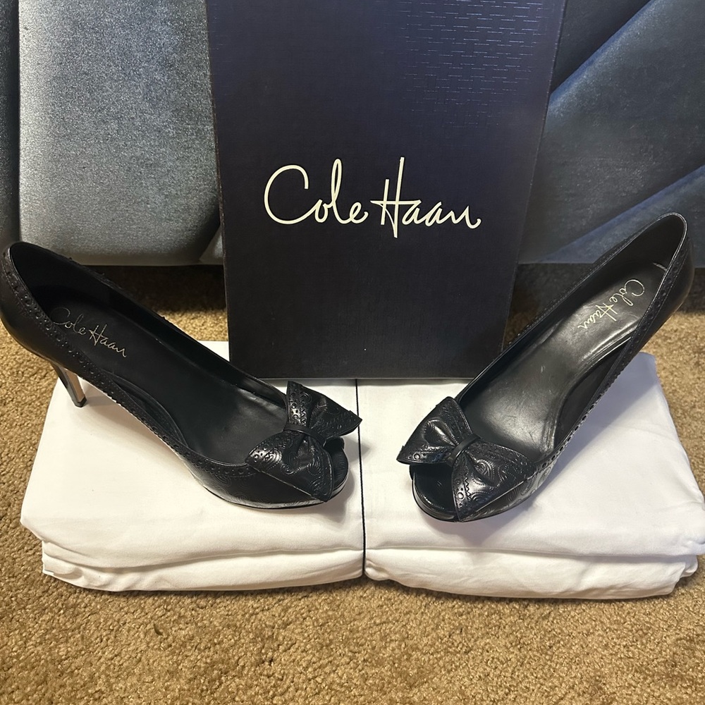 Cole Haan black peep toe heels with leather bow and embellishment.